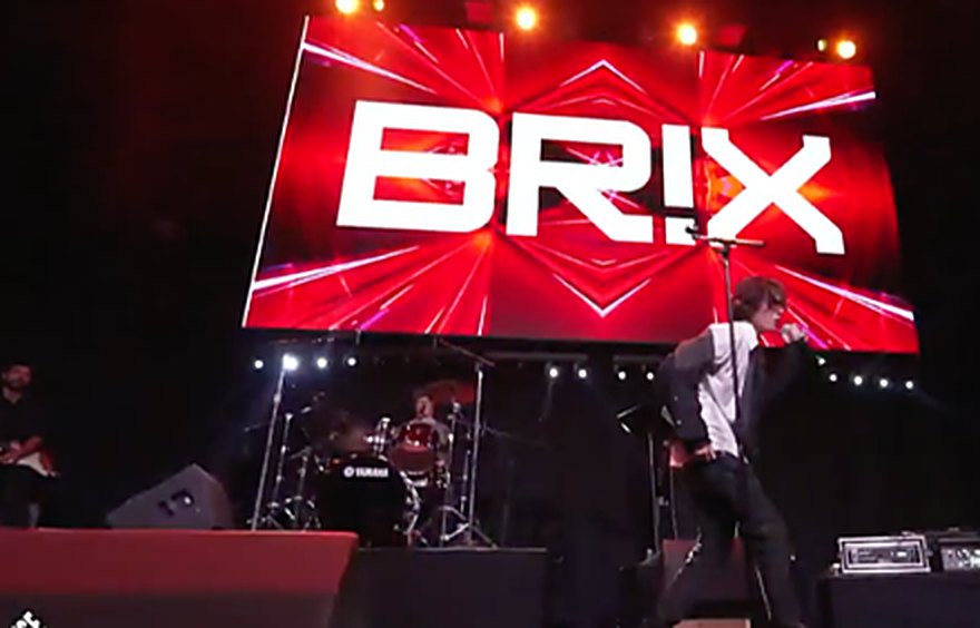 BR!X performing on the Promise2Live global livestream with his logo on the big screen